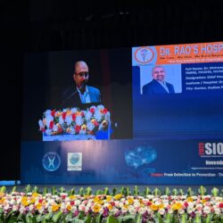 Dr. Mohana Rao Patibandla standing at the podium at SIONCON 2025 in Bengaluru, with a large screen displaying his professional profile, qualifications, and fellowships from leading global neurosurgery centers.